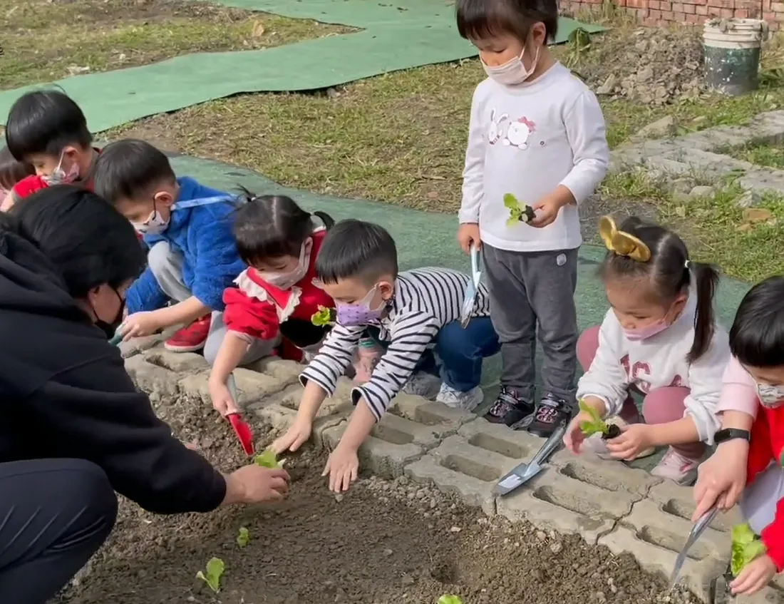 孩子們在校園農場裡彎腰種植、觀察作物生長