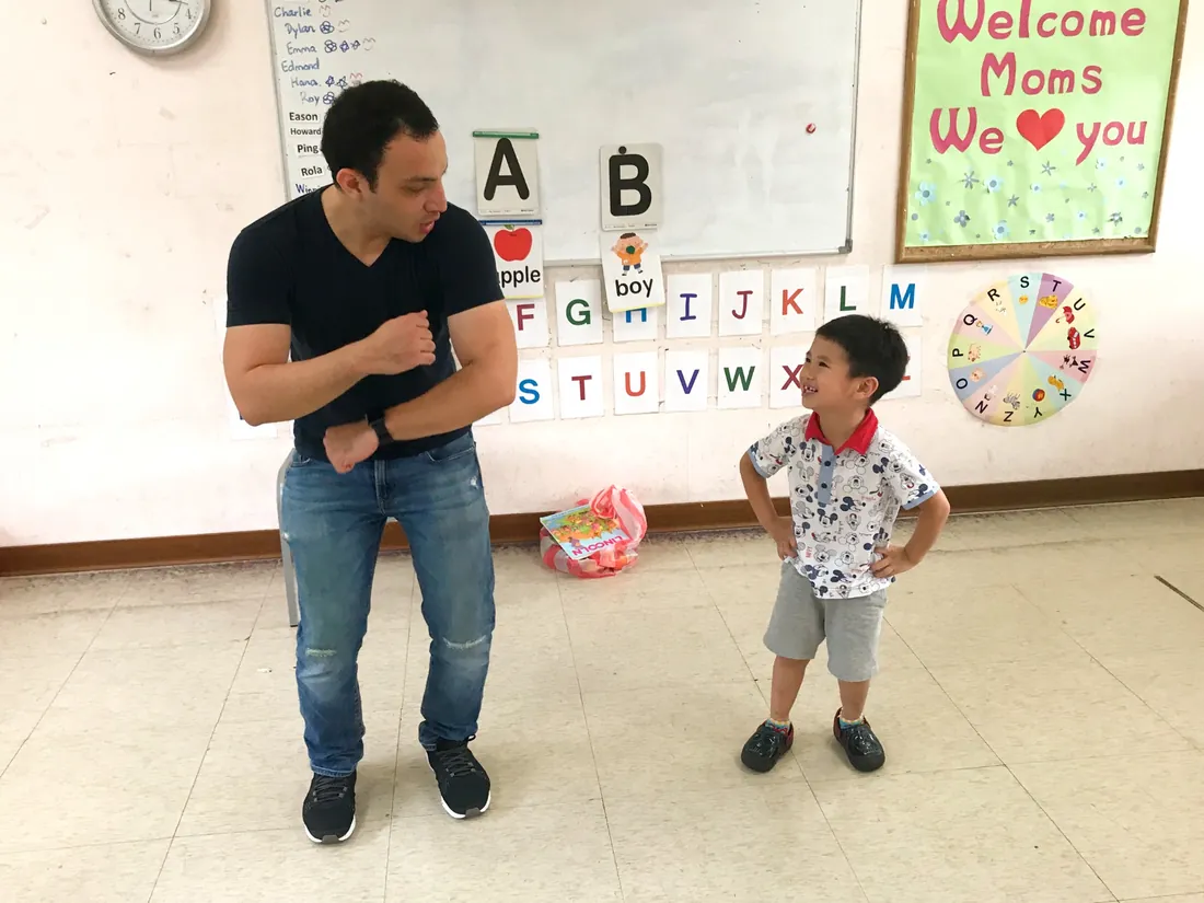 老師蹲下身與孩子面對面互動、微笑交流